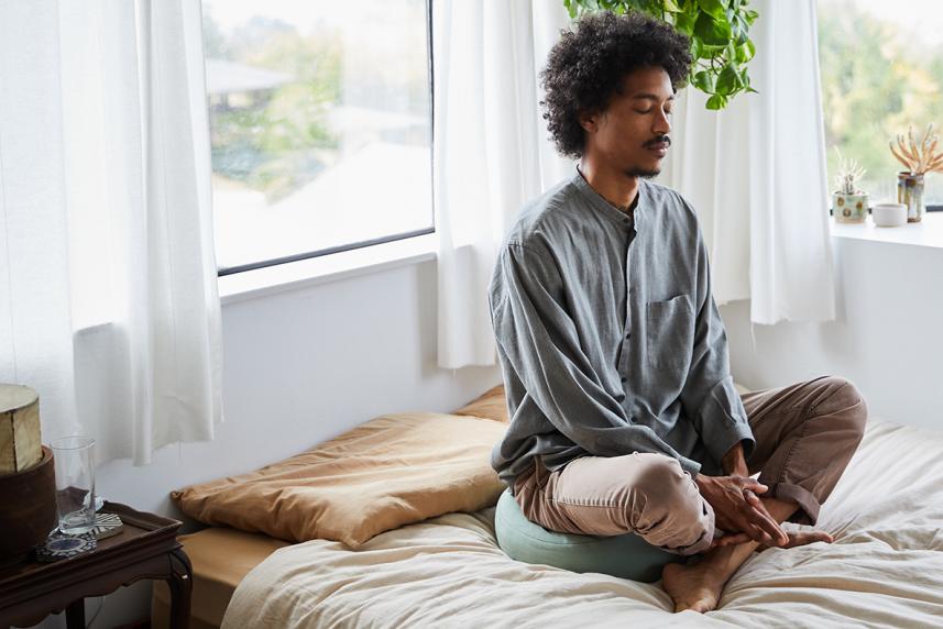 Person meditating on the bed